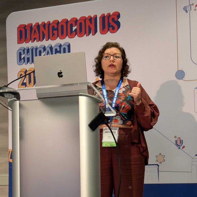 Mariana Bedran presenting her lightning talk on the main stage of DjangoCon 2026.