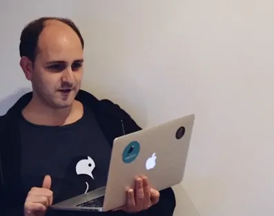 Matt Westcott holding a laptop and smiling.
