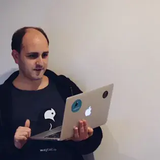 Matt Westcott holding a laptop and smiling.