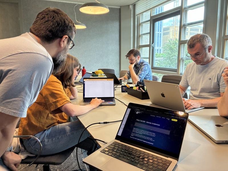 Small group working around a table with laptops before the Wagtail Space sessions begin